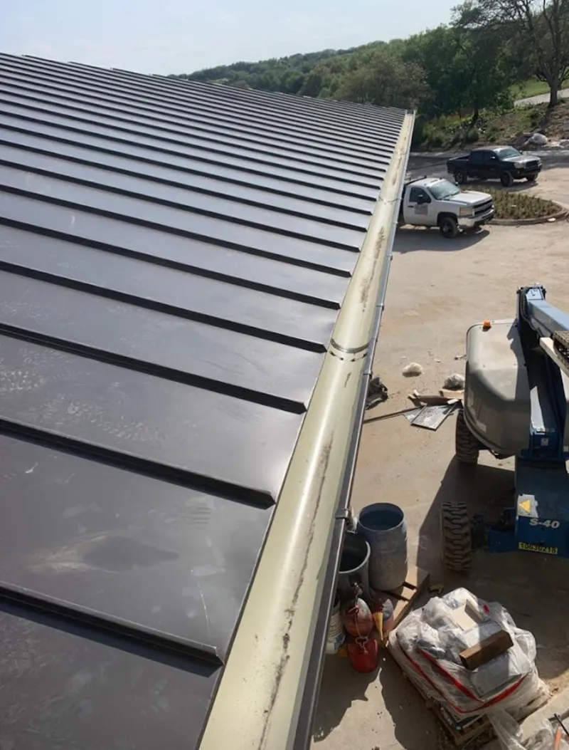 Standing seam panel and gutter detail on a metal roofing jobsite in Corinth